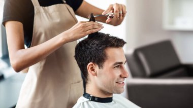 Genç adamın kuaförde saçını kestirirken yakın plan, boş alan.
