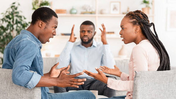 Брачная терапия. Шокированный семейный консультант, игнорирующий чёрную пару, эмоционально спорящую в его офисе, кричащую друг на друга, избирательную сосредоточенность