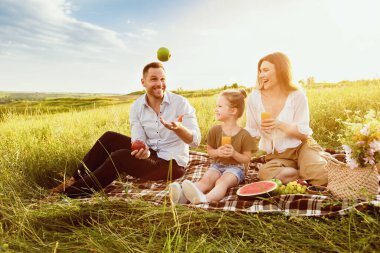 Heyecanlı adamın elmalarla hokkabazlık yapması piknik sırasında ailesine numaralar göstermesi, boş alan.