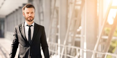 Bavulları havaalanından geçen sakallı zengin bir işadamı fotokopi alanı, manzara ve güneş ışığına bakıyor. Takım elbiseli yakışıklı adam iş gezisine çıkıyor, uçağa biniyor.