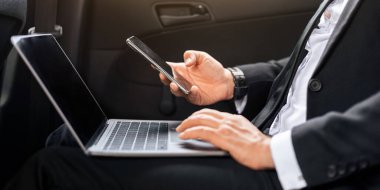 Takım elbiseli bir işadamı dizüstü bilgisayar ve akıllı telefon kullanıyor, internette çalışıyor. Havaalanına giderken defter üzerinde çalışan tanınmayan bir adam. İş dünyasındaki modern teknolojiler