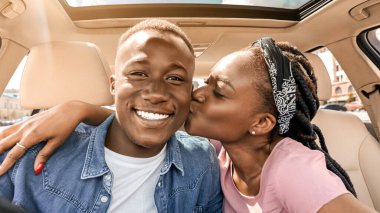 Afro-Amerikalı çiftin araba gezisi sırasında selfie çekmesi, arabada oturması, kameraya sarılıp gülümsemesi, binlerce yıllık siyahi kadının sevgilisini öpmesi, yakın plan portresi.