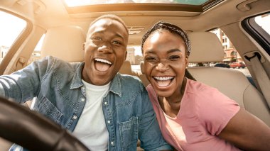 Arabadaki neşeli Afrikalı çiftin portresi. Yolculuğun keyfini çıkarıyorlar, güneş parlıyor.