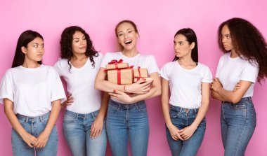 Pembe Stüdyo 'nun arka planında duran bir sürü hediye kutusuyla Mutlu Arkadaş' a bakan beş kıskanç kadın. Kıskanç Olumsuz Duygular, Kadın Arkadaşlığı Kıskançlık ve Yargılama Konsepti