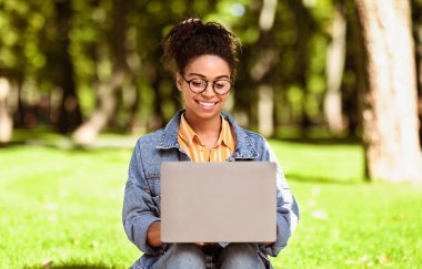 E-öğrenme. Afro-Amerikalı Kız Öğrenci Laptop Bilgisayar Öğreniyor Çevrimiçi İnternet Taraması Açık havada Oturuyor. Uzaktan Eğitim, Eğitim Web Sitesi Kavramı