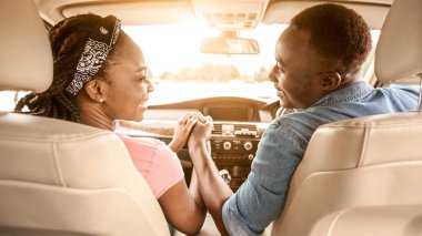 Arabada el ele tutuşan, birlikte seyahat eden Afrikalı çiftin arka görüntüsü.