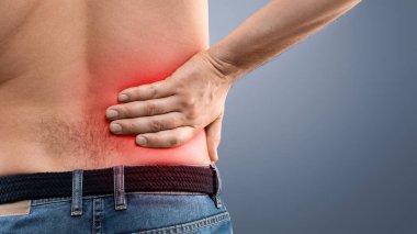 Kırmızı, kronik ya da akut böbrek hastalığı, gri stüdyo geçmişi, fotokopi alanı ile vurgulanmış, fileto bölgesine dokunan tanımlanamayan üstsüz adamın yakın çekimi. Sağlık hizmetleri kavramı