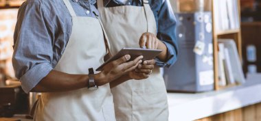 Sosyal medya, internet ve sosyal uzaklık sırasında online düzen. Önlüklü genç Afro-Amerikan ailesi faturalar hakkında konuşuyor ve tablette çalışıyor kafenin içinde, kırpılmış, panorama