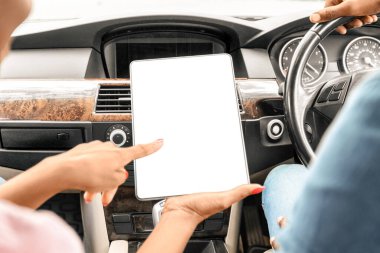 Siyah kadın ellerinde boş ekranla dijital tabletin kapanışı, tanımlanamayan Afro-Amerikan erkek ve kadın birlikte araba ile seyahat ediyorlar, GPS için mobil uygulama kullanıyorlar ya da ped 'de takip ediyorlar,