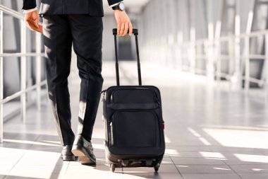 Tanımlanamayan siyah takım elbiseli bir girişimci havaalanı terminalinin yanından geçiyor, bavul ve pasaportla uçuş biletleri ve fotokopi alanı taşıyor. Bavullu zengin işadamı iş gezisine gidiyor.