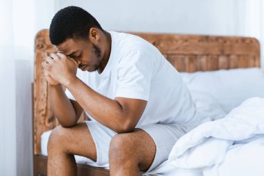 Depresyondaki Afrikalı Amerikalı adam evdeki yatak odasında uykusuzluk çekiyor, sorunları düşünüyor. Erkek Depresyonu, Stresli Modern Yaşam ve Uykusuzluk Konsepti.