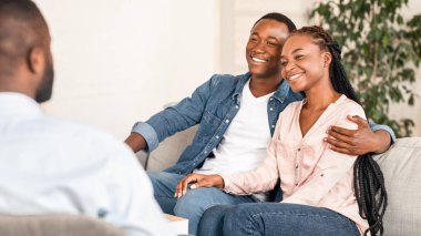 Evlilik uzlaşması. Başarılı bir terapiden sonra Evlilik Danışmanlığı 'nda oturan mutlu Afrikalı Amerikalı eşler, psikoterapide gülümseyen ve kucaklaşan genç siyahi aşıklar, bedava alan.