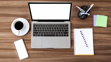 Ofis İşyeri. Düz dizüstü bilgisayar ve cep telefonu, beyaz monitörler, masandaki defter ve kahve.