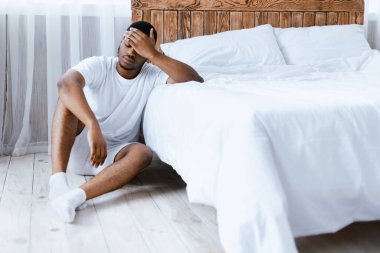 Hasta siyah adamın ateşi ve baş ağrısı var. Alnına dokunuyor. Evde yatarken kötü hissediyor. Sağlık sorunları, Coronavirus hastalığı, grip belirtileri. Metin için Boşluk