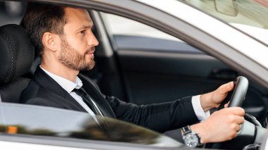 Yakışıklı bir iş adamı, dışarıdan çekilmiş, iş gezisine gidiyor, yan görüş, fotokopi odası. Şık takım elbiseli mutlu adam iş toplantısına gidiyor, lüks arabasını sürüyor.