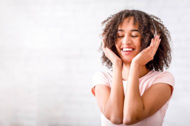 Mutluluk, müzik ve alet. Çevrimiçi şarkıların tadını çıkaran kulaklıklı neşeli Afro-Amerikan kadınlarına odaklanın. Oturma odasında covid-19 'dan kendini soyutlama sırasında, bulanık arka plan.