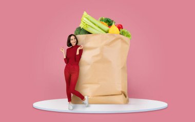 Taze sebze ve meyvelerle dolu büyük bir kesekağıdının yanında duran bir müşteri, canlı bir ortamda market alışverişinin neşesini vurguluyor..