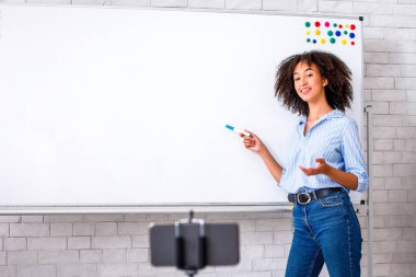 Yazışma eğitimi ve e-öğrenme. Afrikalı Amerikalı kadın İngilizce kurallarını açıklıyor ve takipçiler için video çekiyor, kopyalama alanı.