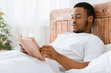 Siyah adam sabahları kitap okumaktan zevk alıyor. Evde rahat bir yatakta uzanıyor. Solucan Adam, Hafta Sonu Yatak Odası 'nda Dinlenen Uzun Roman okuyor. Daha Fazla Kavram Oku. Seçici Odaklanma