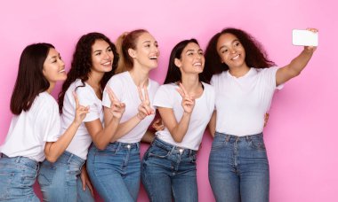Çeşitli Kadın Grup Selfie 'leri. Akıllı Telefonlu Neşeli Çok Irkçı Kadınlar Pembe Stüdyo arka planında kendi portrelerini yaparken eğleniyorlar. Kadın Arkadaşlığı Konsepti.
