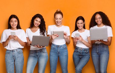 Çevrimiçi Telefon ve Bilgisayar Ağı Kullanan ve İnternet Tarayıcı Stüdyo Çekimi yapan Neşeli Beş Kadın. Farklı Yeteneklerle Mutlu Bayanlar Poz Veriyor
