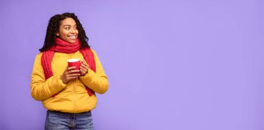 Kışın ceketli siyah bayan elinde kahve fincanı tutuyordu. Sıcak içecek pozu veriyordu. Mavi Stüdyo Arkaplanı 'nda fotokopi uzayına bakıyordu. Mutlu Kış ve Sonbahar Sezonu, Teklif Reklamları