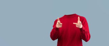 Kırmızı kazaklı başsız bir insan, oyuncu parmak tabancası hareketleriyle poz verir. İzole edilmiş arka plan, yaratıcı projeler için çarpıcı bir görsel etki yaratan eşsiz yaşam tarzı kavramını vurgular..