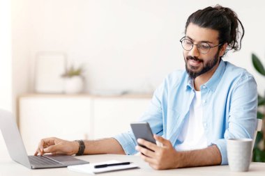 Milenyum Arap Serbest Çalışan Adam, İçişleri Bakanlığı 'nda bilgisayar başında çalışırken akıllı telefon kullanıyor, arkadaşlarıyla yeni başvuru ya da mesajlar okuyor, uzak iş fırsatlarının tadını çıkarıyor, Uzay' ı kopyalıyor.