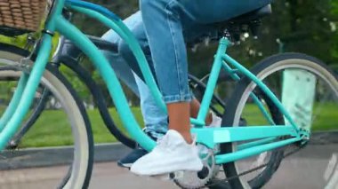 Bir çift canlı bir parkta bisiklet sürüyor, açık havanın tadını çıkarıyorlar. Güneş ışıl ışıl parlıyor onlar yol boyunca ilerlerken, anın özgürlüğünü hissederek.