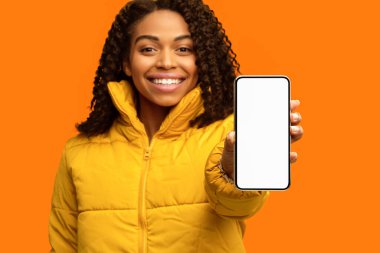 Gülümseyen Afrikalı Kız Cep Telefonu Ekran Görüntüsü Sarı Stüdyo Arkaplanda Kışlık Giysiler Giyiyor