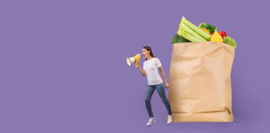 Bir kişi taze sebzelerle dolu büyük bir kesekağıdının yanında duruyor, canlı bir ortamda market teslimatını desteklemek için megafon kullanıyor..