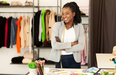 Moda tasarımcısı. Gülümseyen Afrikalı Afro-Amerikalı Kız, giyinme odasında dikiliyor. Boşluğu Kopyala