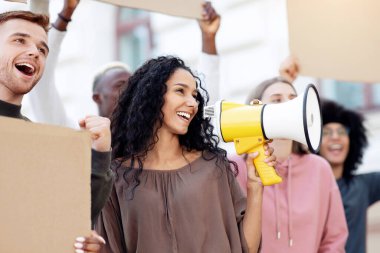 Sokaklarda grev yapan motive olmuş uluslararası öğrenciler ellerinde boş pankartlar ve hoparlörlerle sloganlar atıyorlar. Kapatıyorlar. İnsan hakları için savaşan çok ırklı gençler grubu