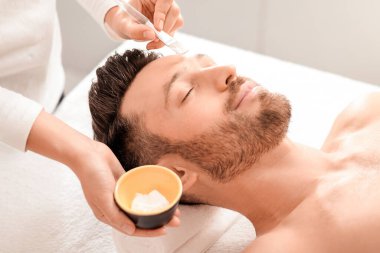 Rahat bir adam kozmetolojist ya da spa salonuna gidiyor, hafta sonunun tadını çıkarıyor. Sakallı, orta yaşlı bir adam yüz bakımı görüyor, tanınmayan bir spa görevlisi yüzüne besleyici maske takıyor,