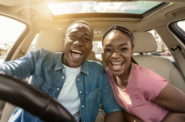 Arabadaki neşeli Afrikalı çiftin portresi. Yolculuğun keyfini çıkarıyorlar, güneş parlıyor.