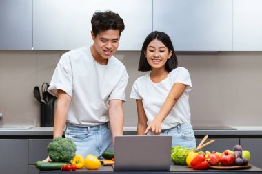 Heyecanlı Koreli Çift Laptop Yemek Pişiriyor Lezzetli Yemek Tarifleri Çevrimiçi Yemek Hazırlıyor Modern Mutfakta Birlikte Bekliyoruz. Aile Beslenme, Yemek Hazırlama Konsepti. Seçici Odaklanma