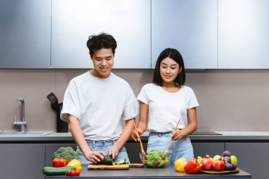 Çinli çift mutfakta birlikte yemek pişiriyor ve hafta sonları iki kişilik sağlıklı yemek hazırlıyor. Evde sebze salatası yapıyorlar. Beslenme ve Diyet Tarifleri