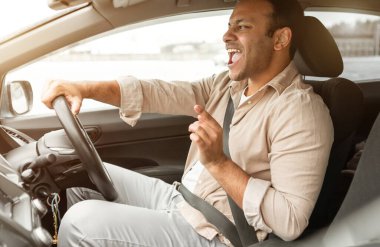 Yol Yolculuğu Çalma Listesi. Neşeli Hintli Sürücü, yeni arabasını sürerken şarkı söylüyor, favori müziğin ve hızlı araba sürmenin tadını çıkarıyor. Otomobil Sahipliği Konsepti. Yan Görünüm Görüntüsü