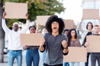 Sokaktaki bir grup göstericiyi yöneten duygusal melez adam. İnsan ya da hayvan haklarını ve ırkçılığı protesto eden boş pankartlı uluslararası çeşitli insanlar.
