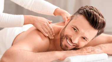 Neşeli orta yaşlı bir adam hafta sonu kaplıcaya gidiyor, kapanış. Sırt masajı yaptırırken kameraya gülümseyen yakışıklı sakallı adam. Kadın terapist spa salonunda neşeli erkeğin omuzlarını ovuyor.