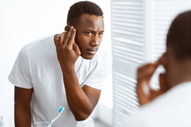 Saç dökülme problemi. Aynaya Bakan Afrikalı Amerikalı Kafasına Dokunan Adam Evde Banyo 'da Erkek Kel Sorunu Var. Erkek Güzelliği ve Saç Bakımı ve Çözümler Konsepti