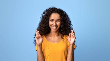 Sevgili Dilek. Pozitif esmer kadın şans diliyor, şans diliyor, mucize için dua ediyor, iyi şeyler olmasını umuyor, Mor Stüdyo geçmişinin başında duruyor,