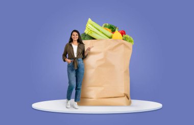 Bir müşteri taze sebze ve meyvelerle dolu büyük kahverengi bir kese kağıdının yanında duruyor. Bu güncel alışveriş alışkanlıklarını yansıtıyor, gıda alımındaki yeni normalliği gösteriyor.
