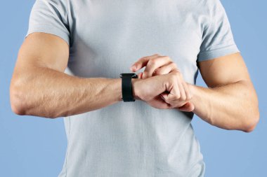 Tanımlanamayan genç sporcu menekşe stüdyosunun arka planında kendini kontrol ediyor. Spor yaparken spor takip cihazı kullanan bin yıllık sporcunun görüntüsü. Modern spor teknolojileri