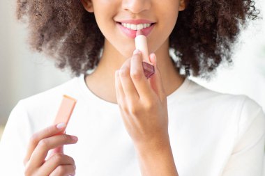 Gülümseyen genç ve güzel bir bayan elinde ruj ile sabah hazır olsun. Mutlu ve çekici kadın aynaya bakar, makyaj yapar, dudağına makyaj malzemesi sürer, boşluğu kopyalardı.