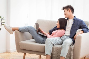 Asyalı bir çift dizüstü bilgisayar kullanıyor. İnternette film seyrediyor. Hafta sonları evdeki koltukta birlikte dinleniyorlar. Modern Yaşam Tarzı, Bilgisayar Kullanıcıları İnternet Konseptini Tarıyor. Metin için Boş Alan