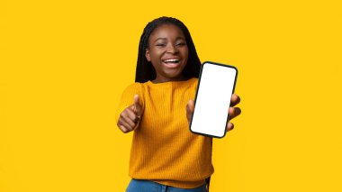Everything Is Great. Positive Black Woman Gesturing Thumbs Up At Camera, Cheerful Smiling African American Lady Posing Over Yellow Background In Studio, Beautiful Young Female Having Fun, Copy Space