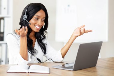 Gülümseyen girişimci ya da ofis çalışanı iş ortağıyla konuşuyor, internette video görüşmesi yapıyor. Milenyum siyahi sekreteri web kamerasından iletişim kuruyor, dizüstü bilgisayar kullanıyor.