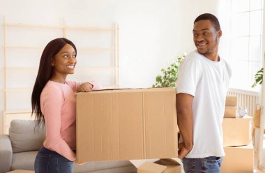 Ev taşıma konsepti. Karton kutulu, arkadaş canlısı siyah çift yeni evine taşınıyor, kopyalama alanı. Milenyum Afrikalı Amerikalı ev sahipleri yeni bir mülke taşınıyor.