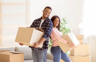 Genç siyahi ev sahipleri taşınma günü, panorama 'daki yeni evlerinde mutlu hissediyorlar. Sevecen Afro-Amerikan çiftin portresi yeni bir daireye taşınıyor.